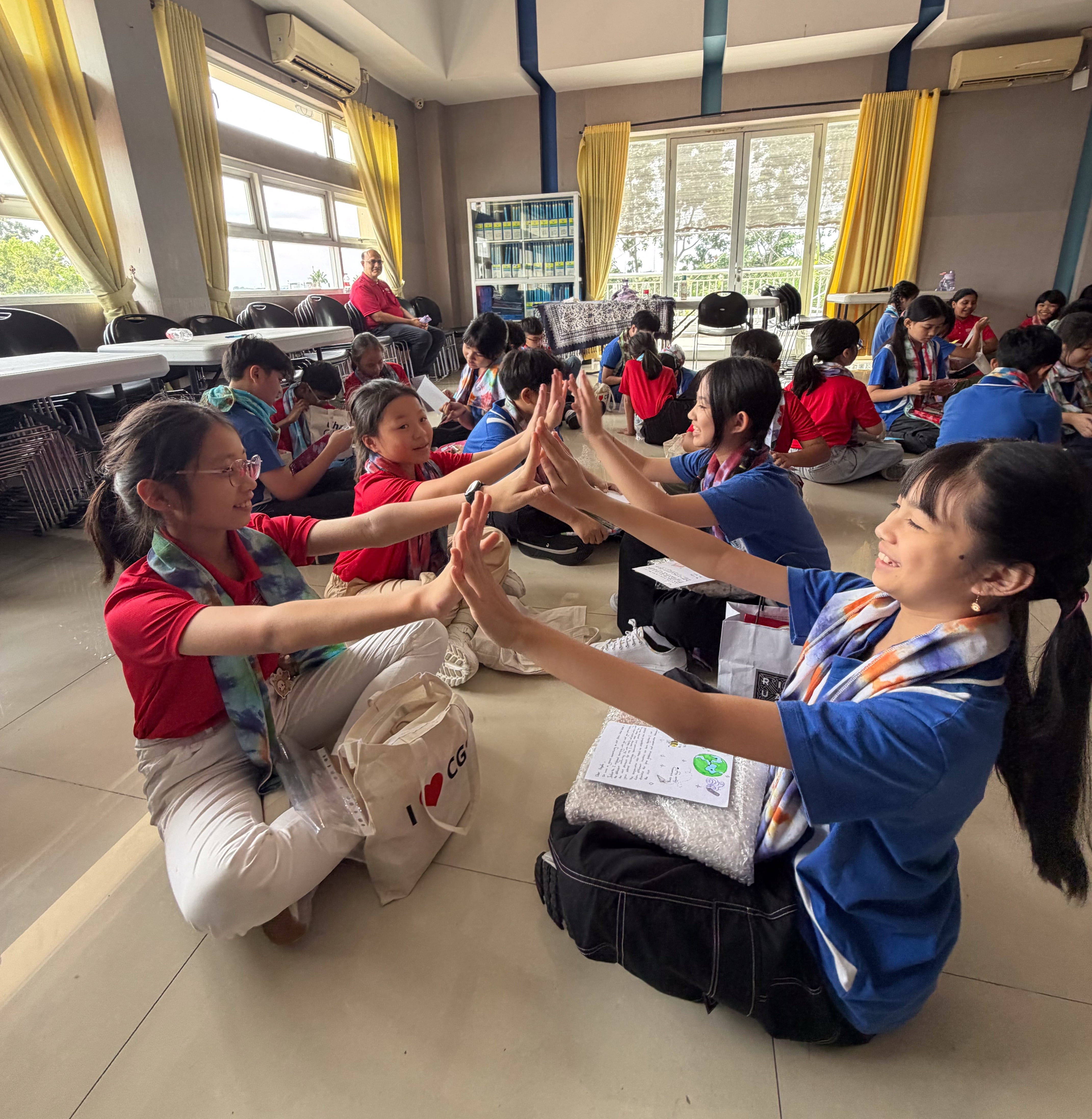 Canberra Primary School and Charis Global School students interacting in pairs during an activity. 