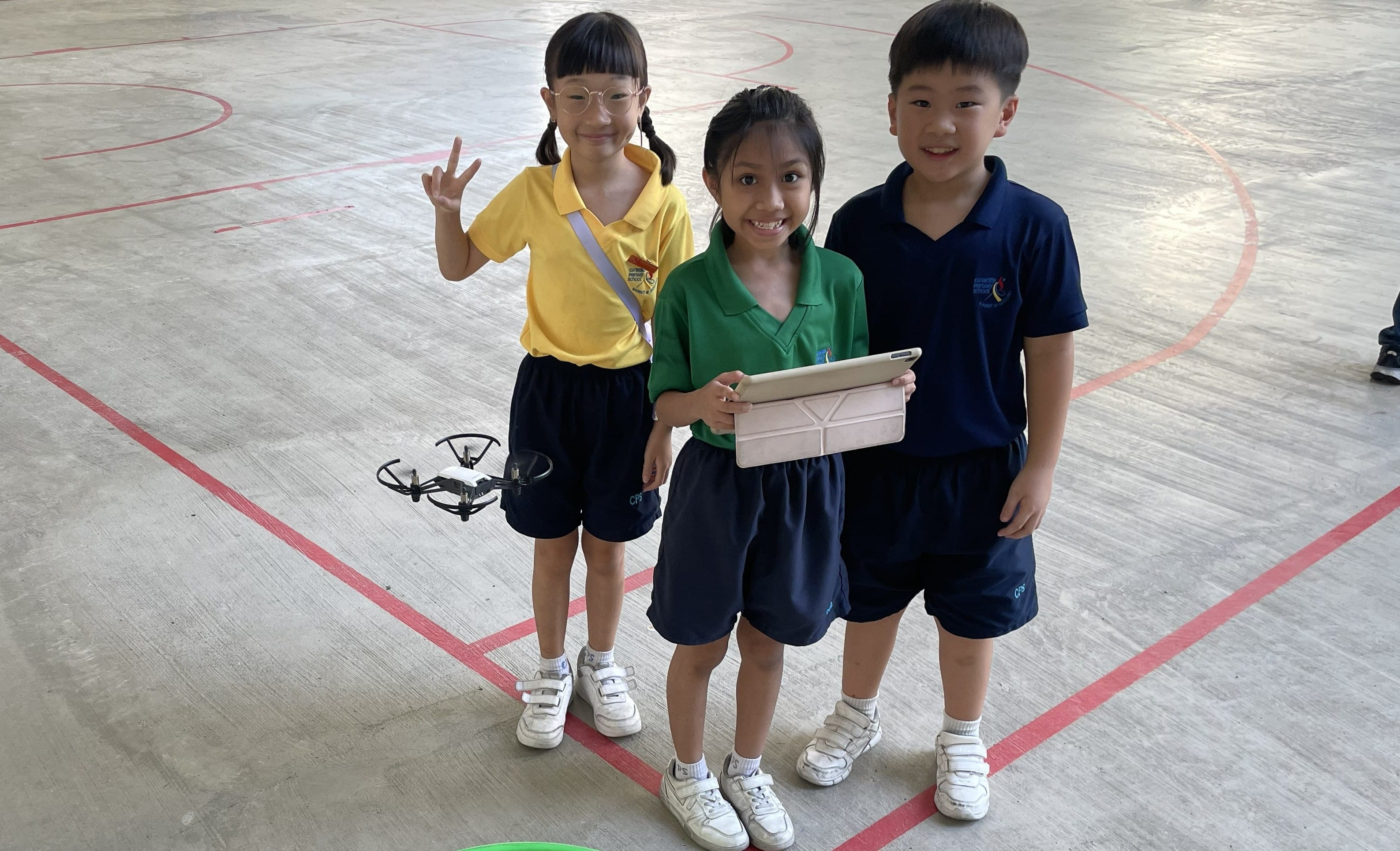 Students pose with their drone flying mid-air during the Coding with Drones programme.