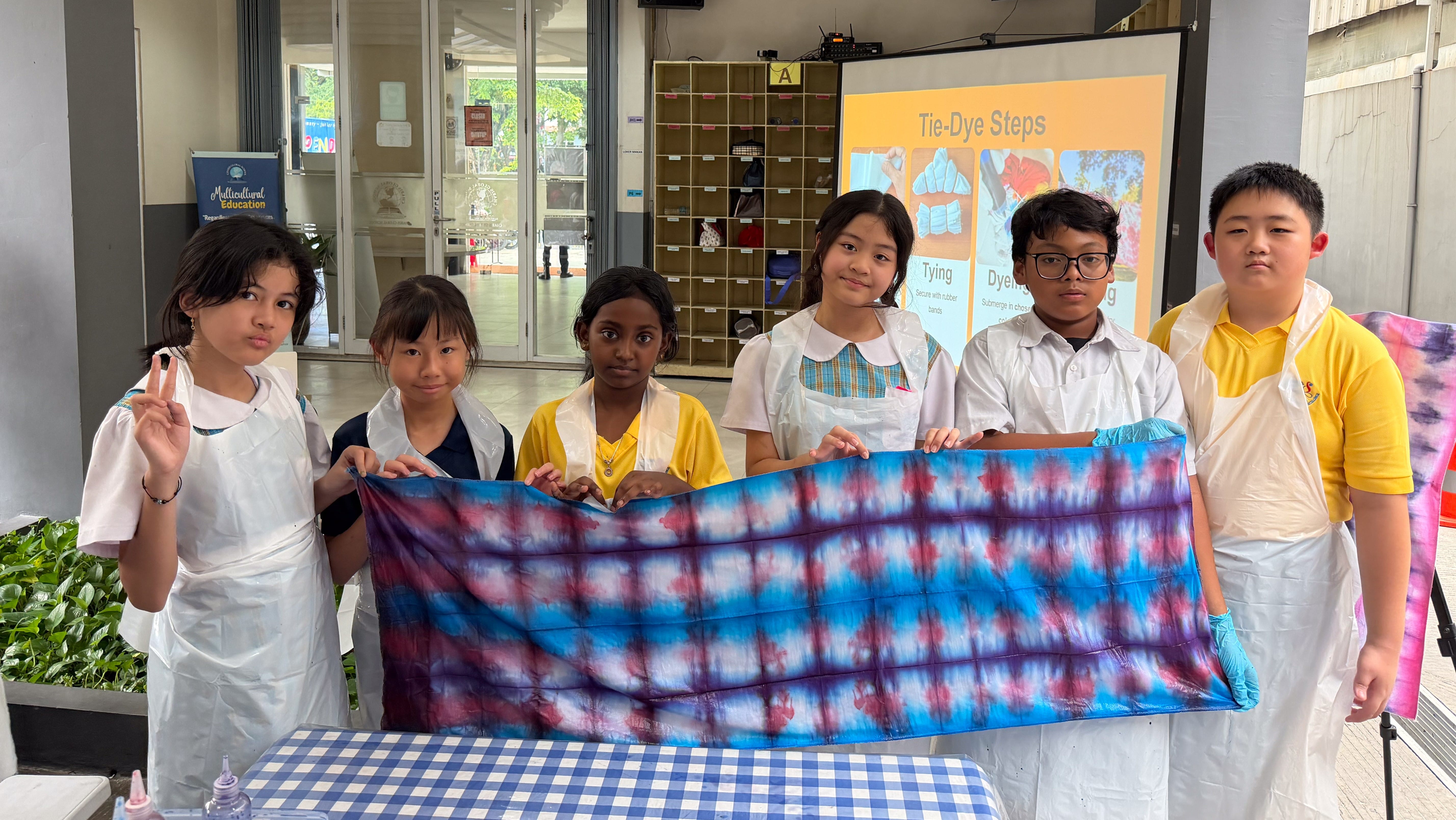 Students displaying their colourful fabric creation during a cultural art activity at Charis Global School. 
