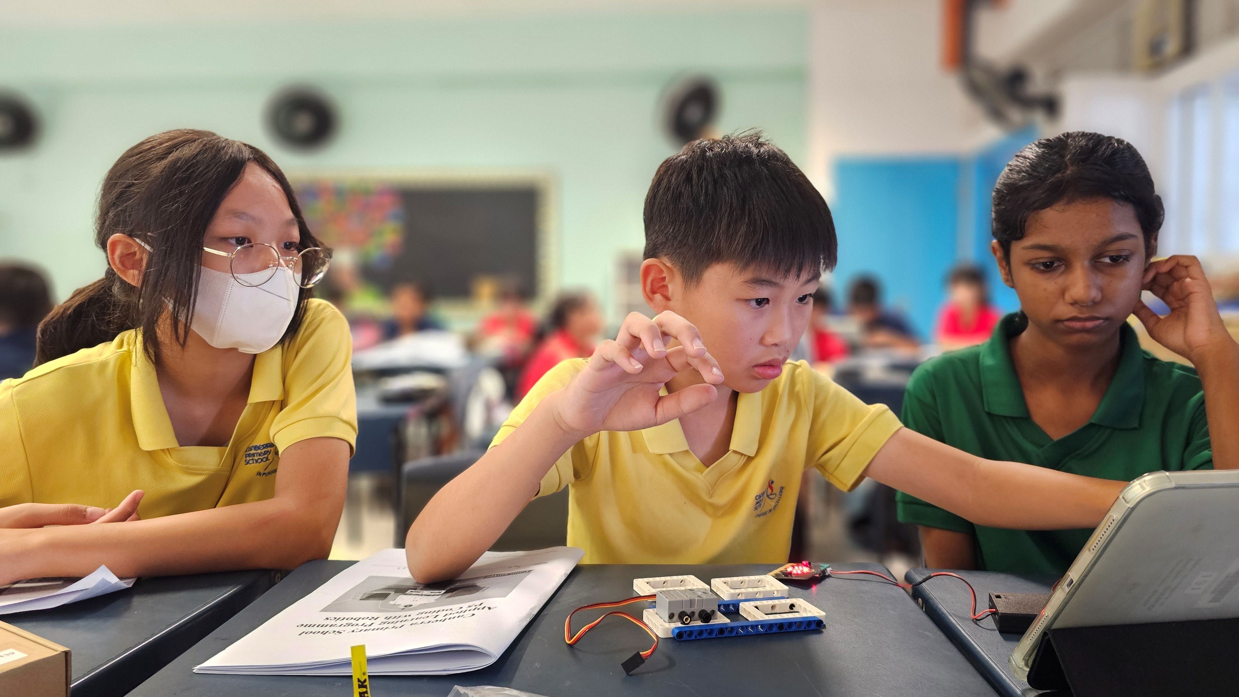 Students discussing their codes for the Coding with Robotics programme.