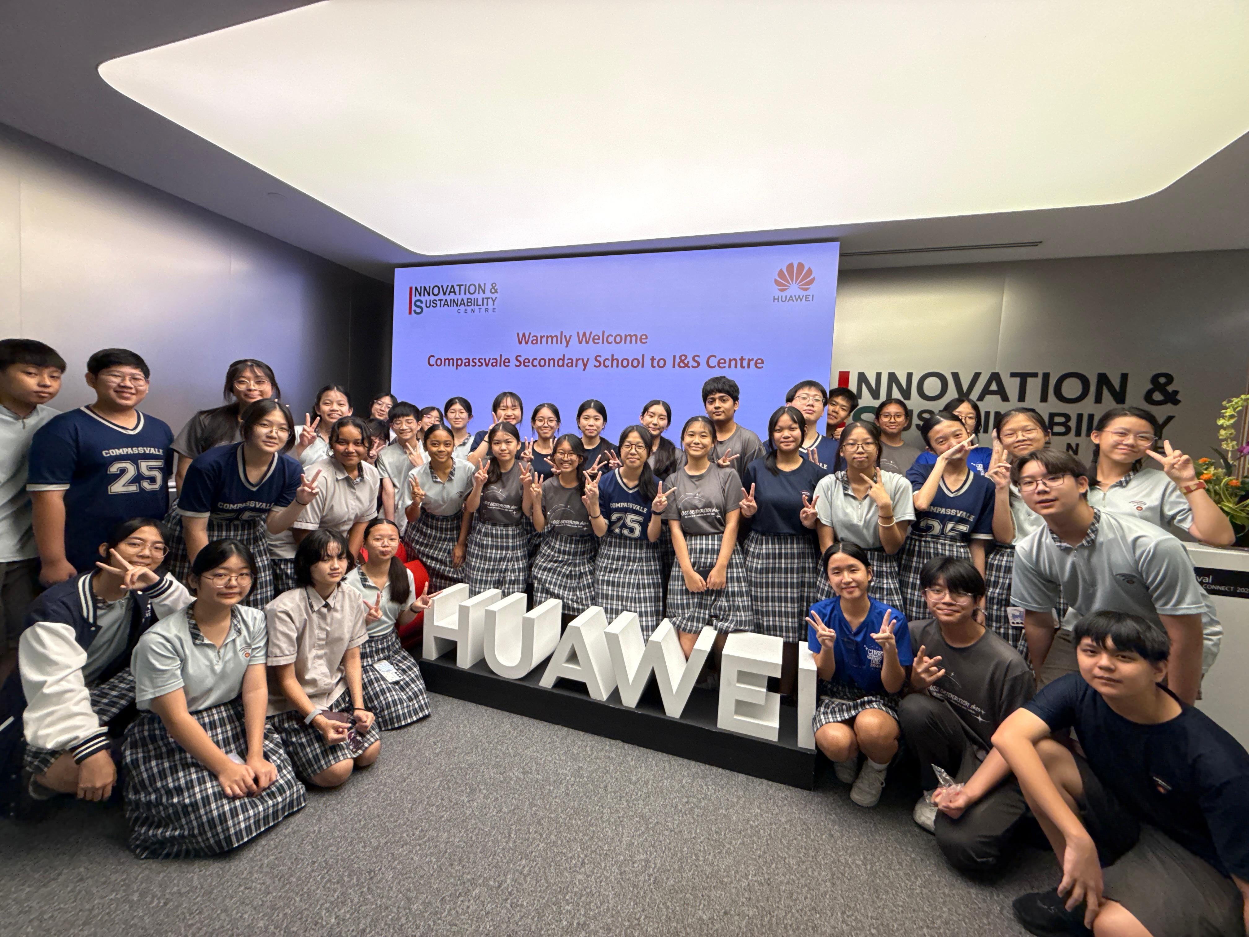 Students from Compassvale Secondary School pose at Huawei's Innovation and Sustainability Centre with peace signs.