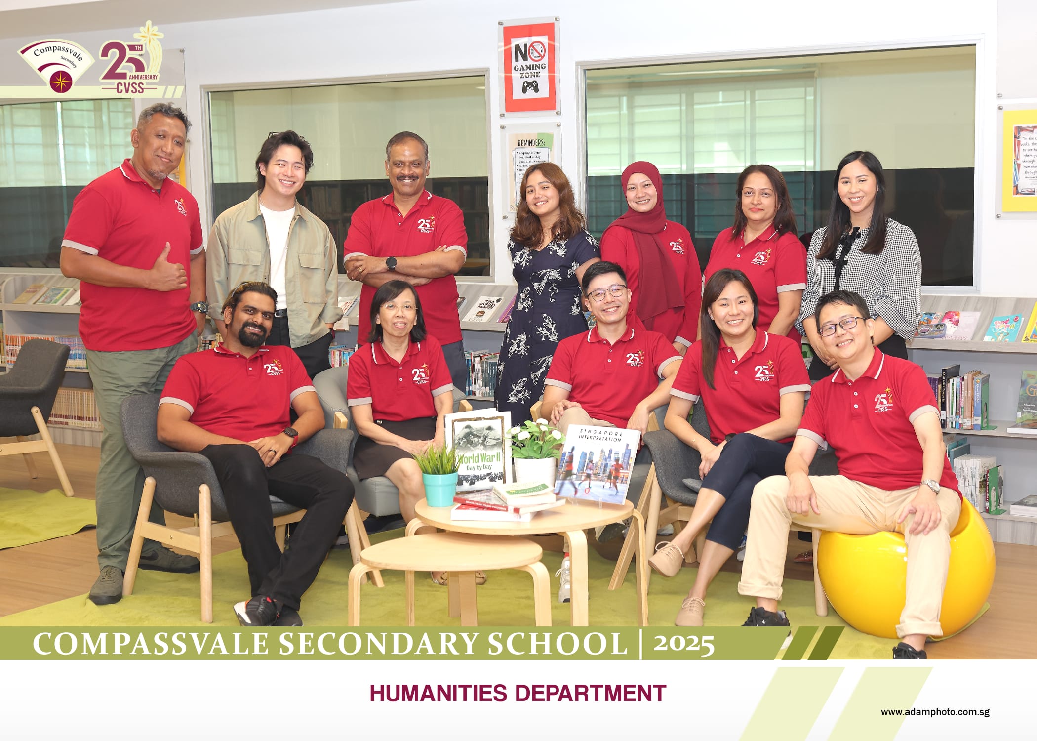 Compassvale Secondary School 2025 Humanities Department staff group photo in a library setting, most wearing red polo shirts.