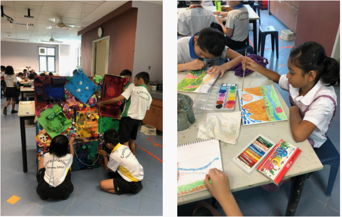 Children doing art activities: one group builds a colorful structure, another group paints with watercolors at a table.