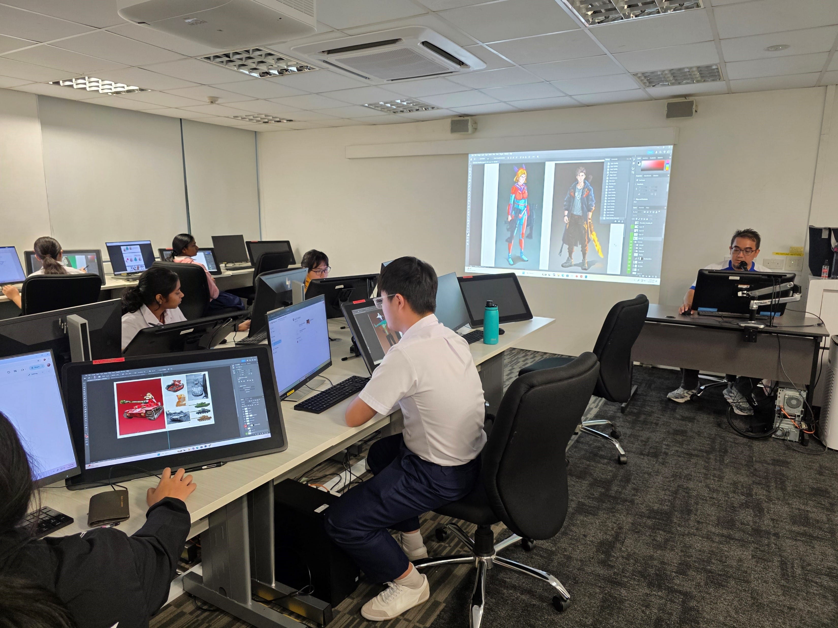 Students work at computers in a digital art classroom while a projected screen displays colorful character designs.
