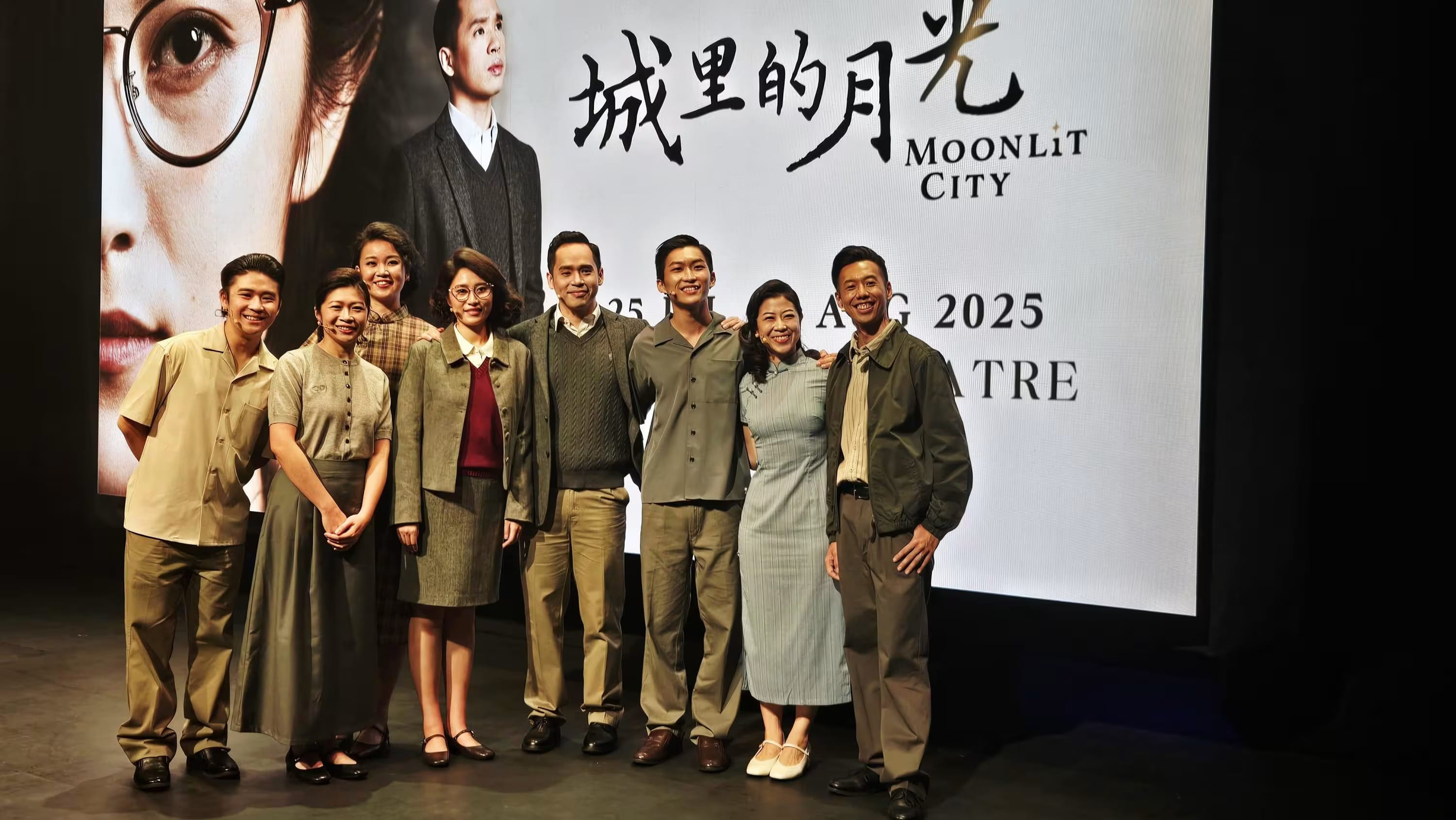 Seven cast members in period costumes pose before a Moonlit City theatre production banner showing 2025 dates.