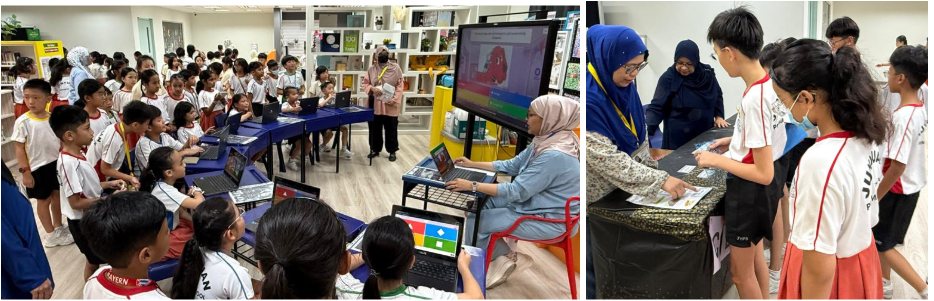 Children gather around teachers using laptops and a large screen display in a school library learning session.