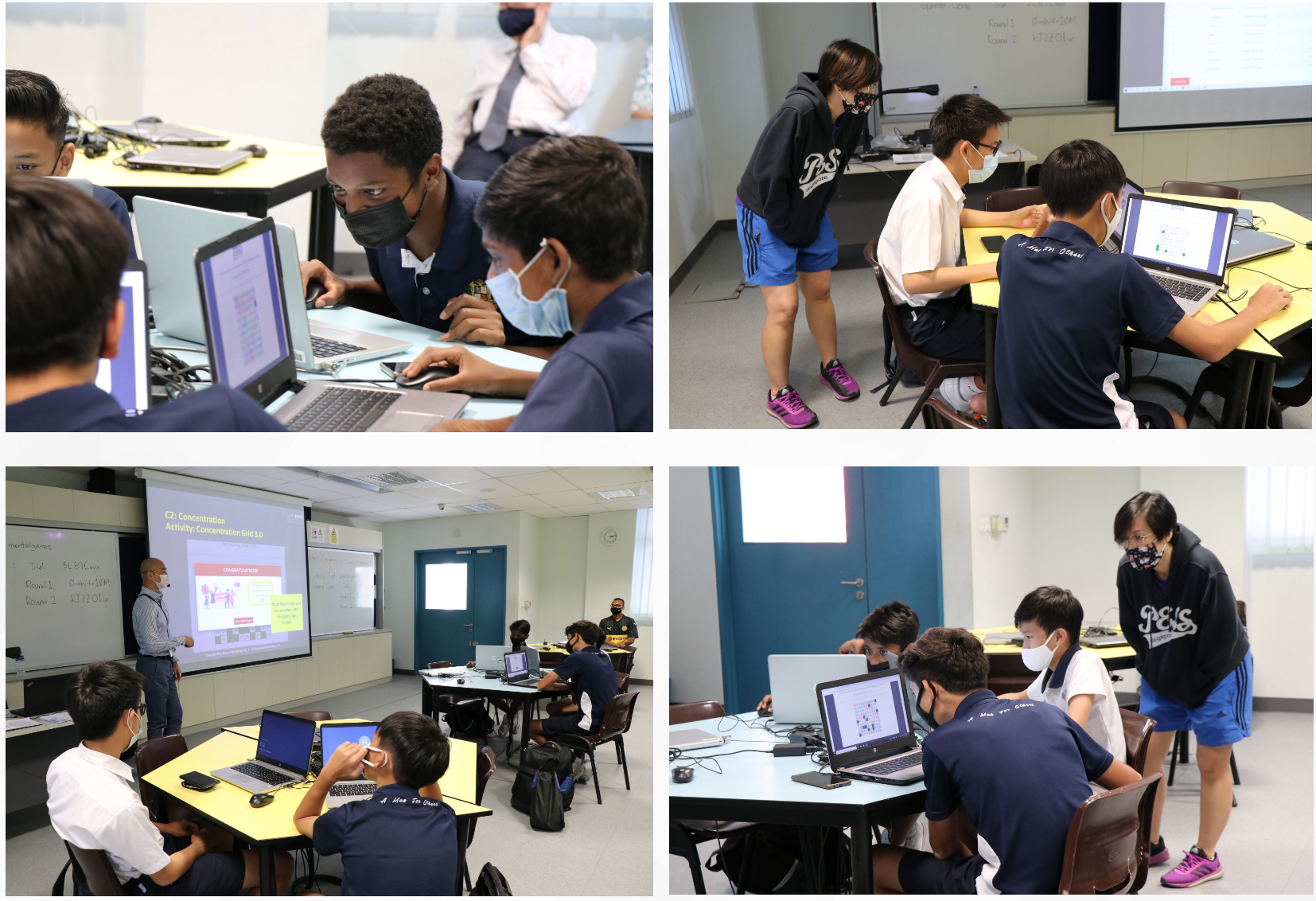 Students wearing masks work on laptops in a classroom while a teacher presents a slideshow on a projector screen.