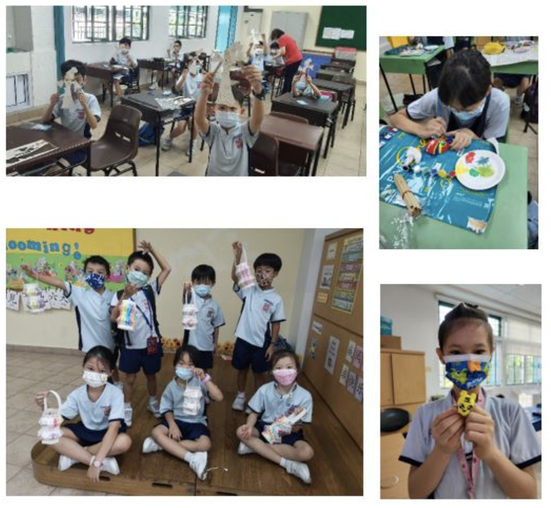 Young students wearing masks hold up colorful handmade crafts in a classroom setting.