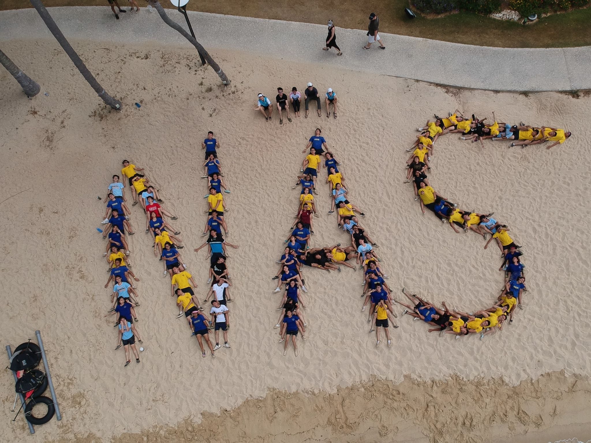 An aerial shot of Student Leaders forming the letters "NAS" at the beach.