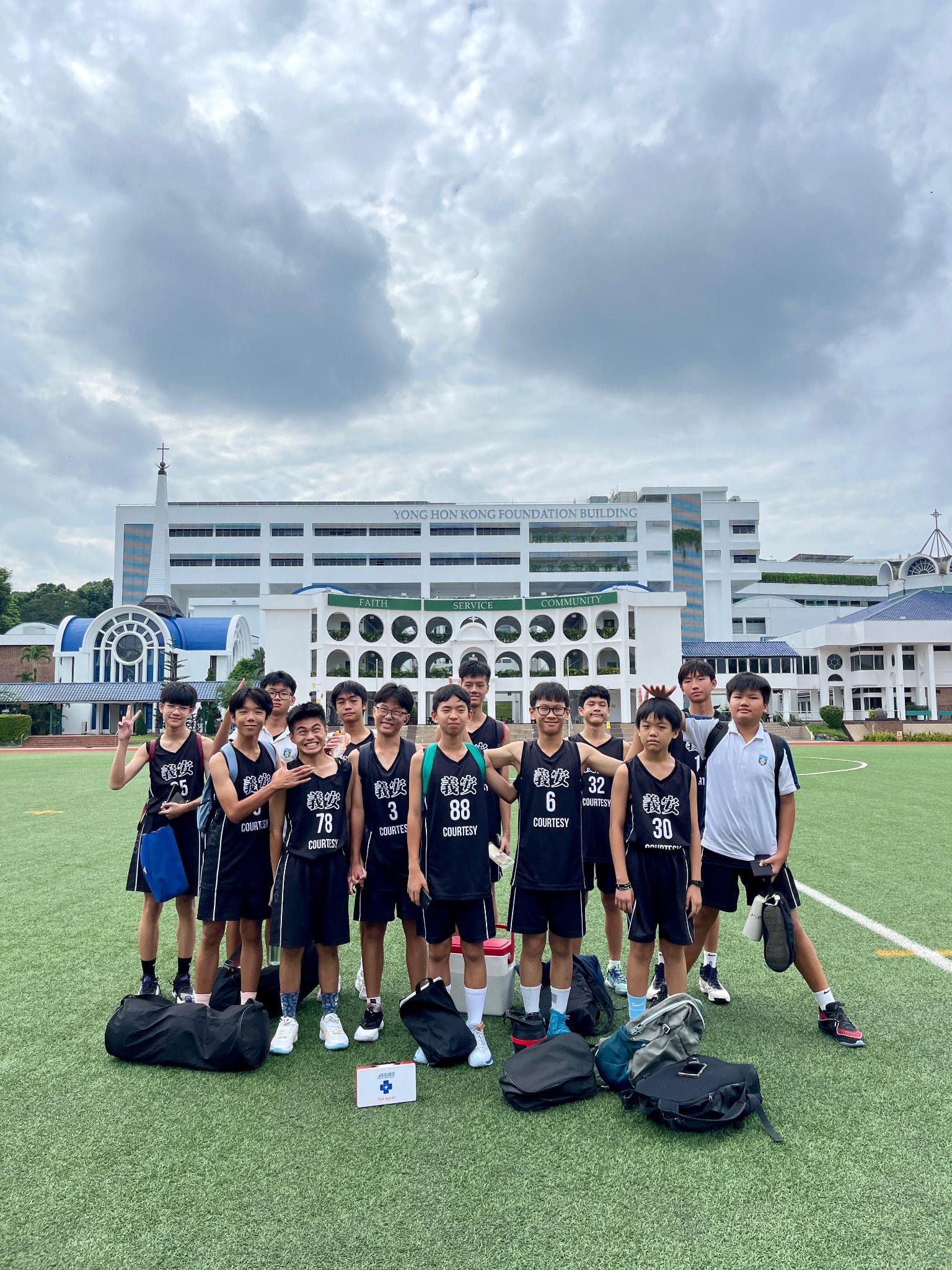 A group photo of the Basketball C Division team after a match at SJI