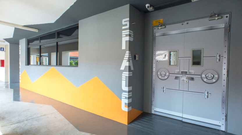 The entrance to the sPACE Helpdesk, featuring its distinctive vault-style door and mountain inspired mural.