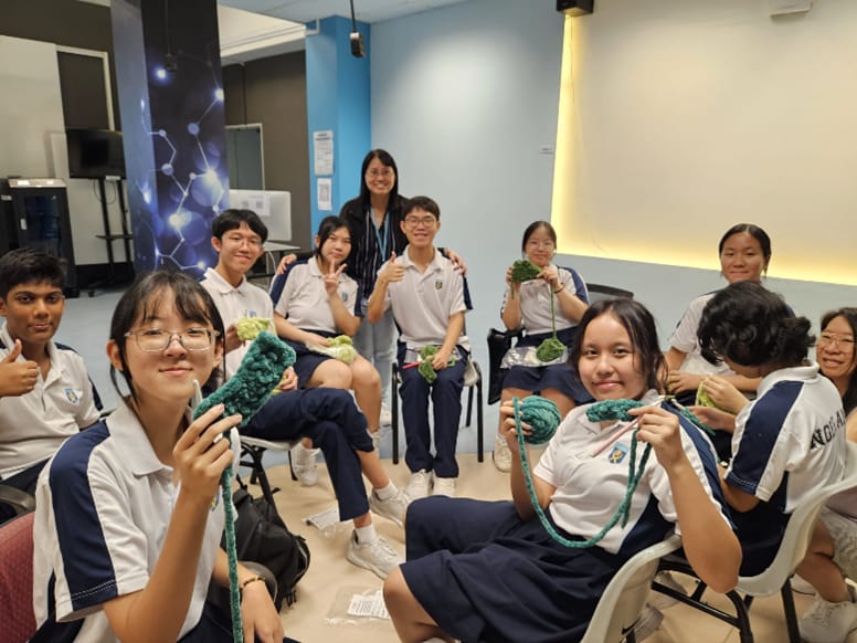 Ngee Ann Secondary students posting with yarn and their crocheted items.