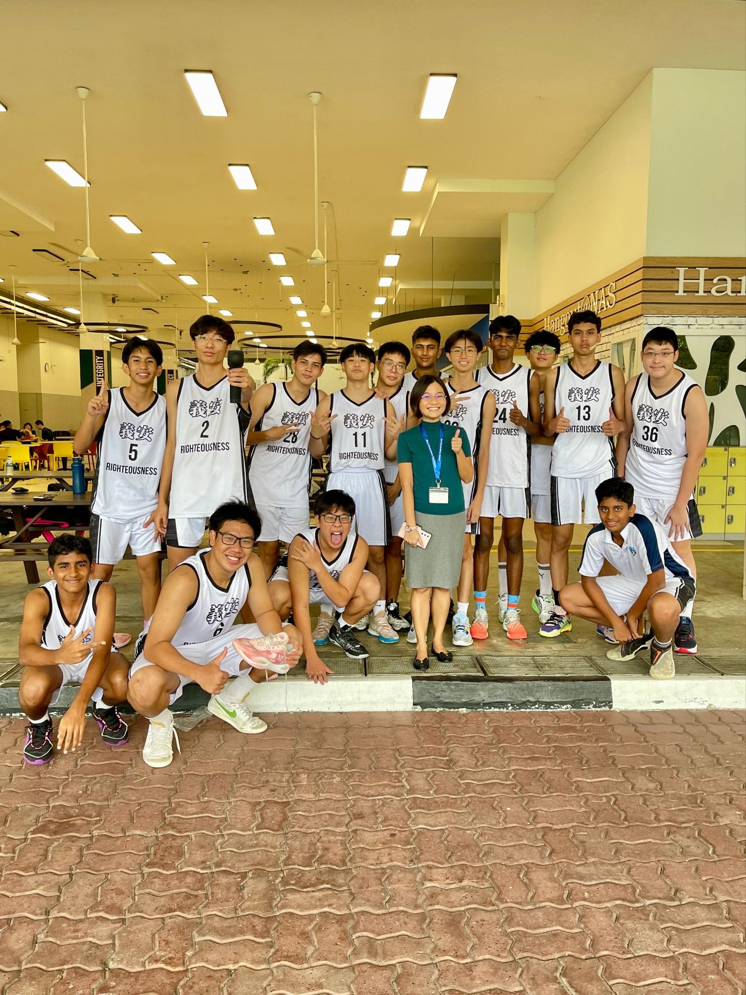 Principal Ms Poh and the Basketball B Division team posing for a photo before their NSG match.