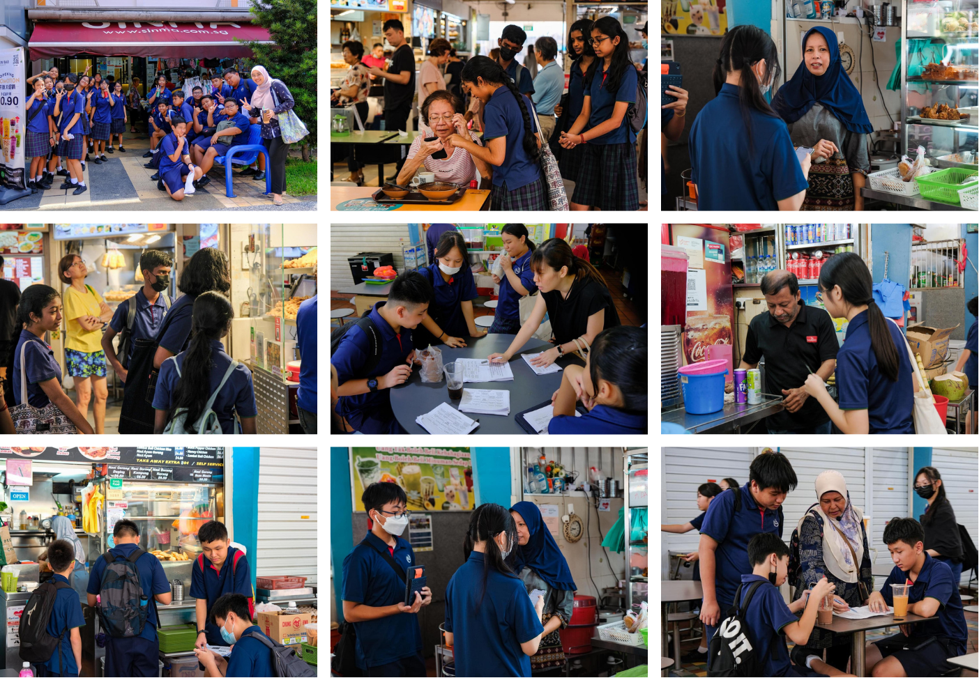 Students in blue uniforms interact with hawker stall vendors and community members at a Singapore food centre.