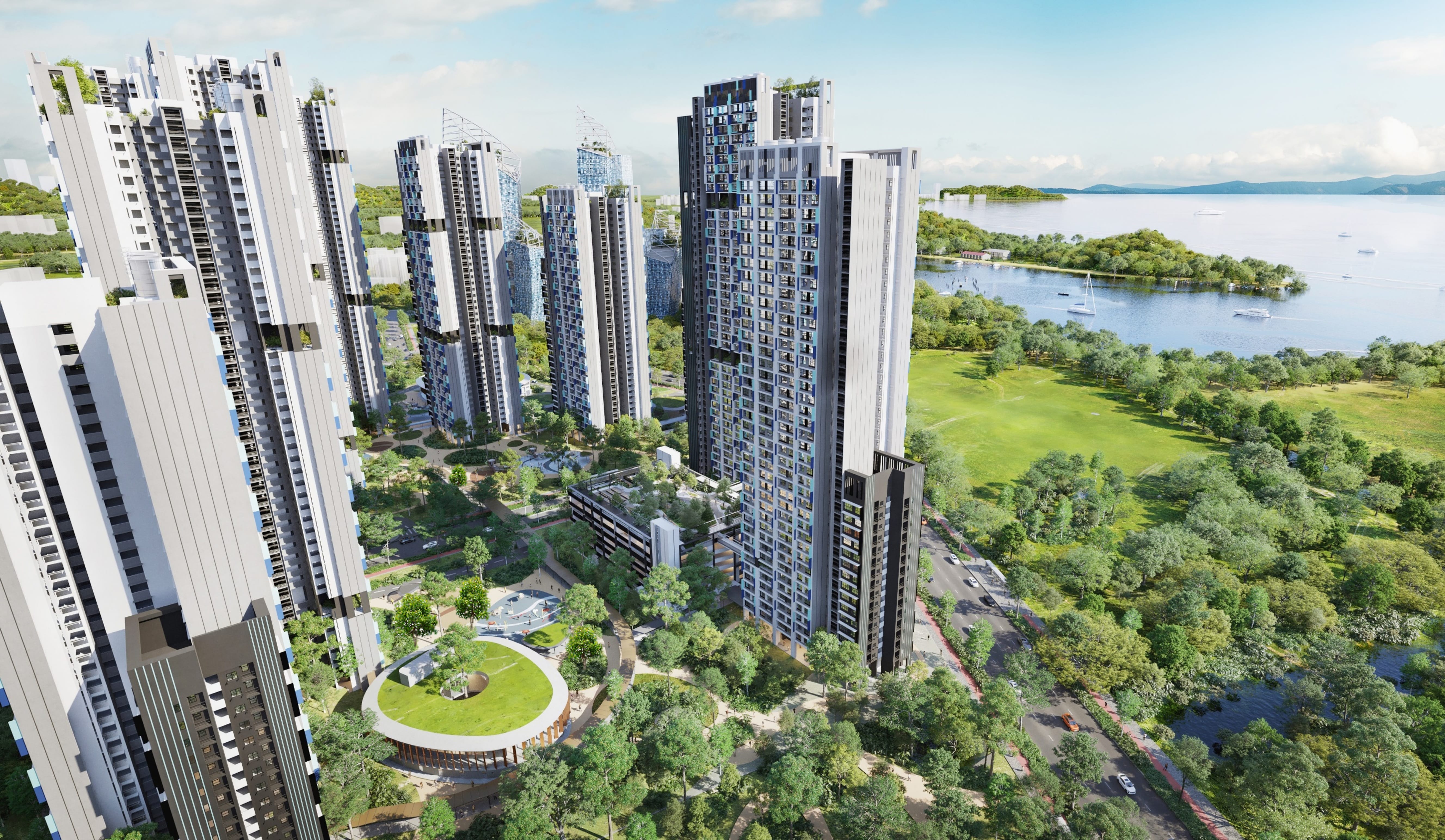Cluster of tall modern apartment towers beside a green park and waterfront with sailboats.