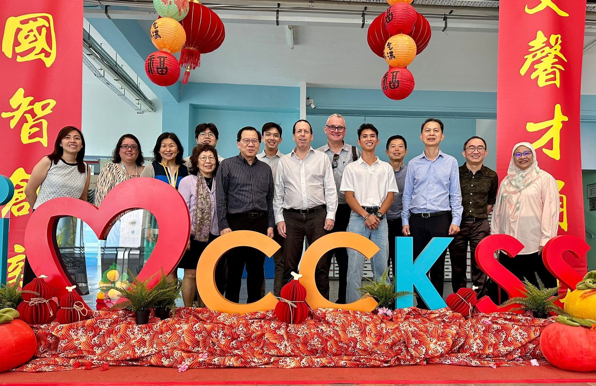 A group of people standing behind the CCKSS sign