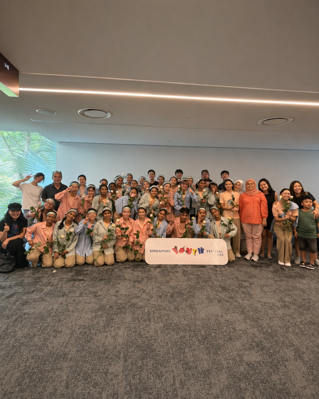 Large group posing with roses behind a Singapore Food Festival 2023 sign indoors.