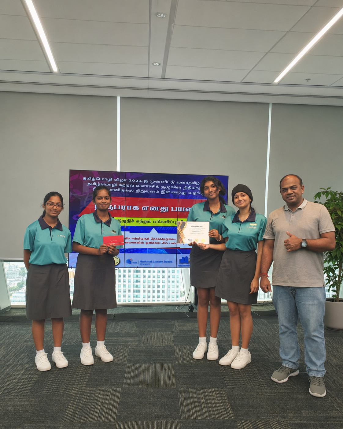 4 girls and 1 teacher pose in front of a screen