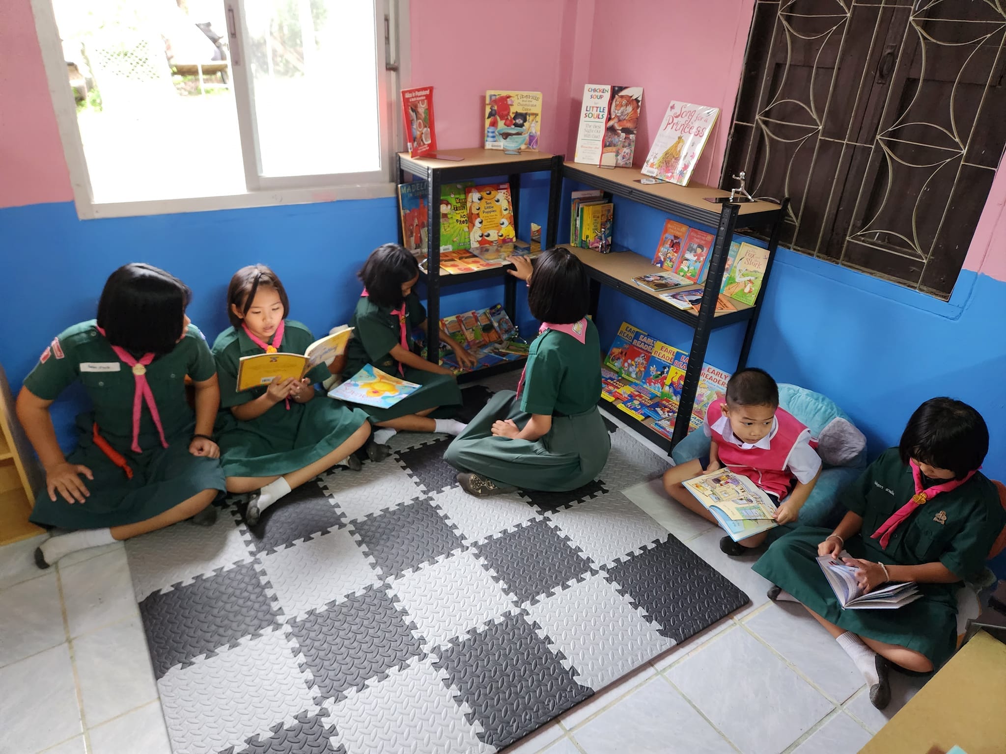 a picture of a decorated library with seven students reading books.