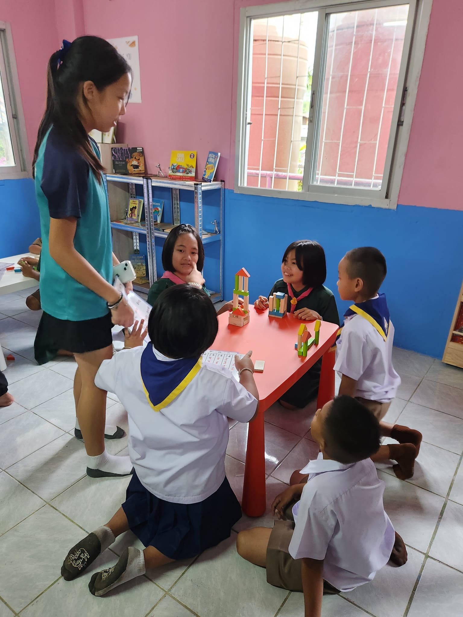 A group of students playing with blocks at a low table.