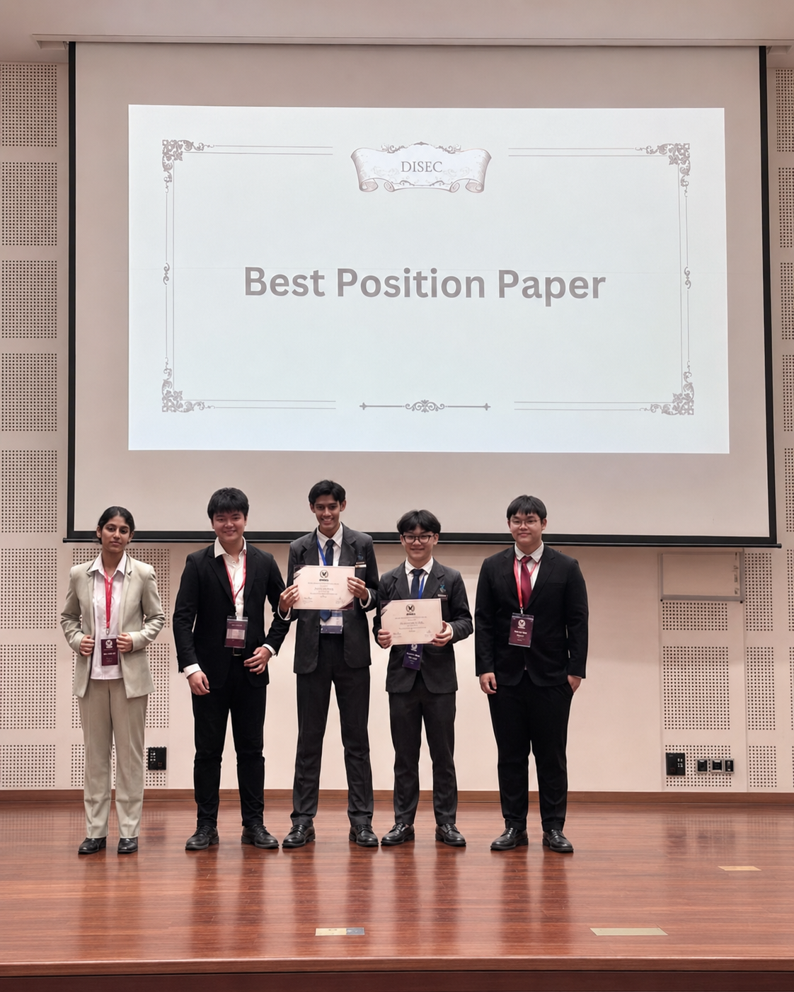 a group of students holding certificates in front of a screen