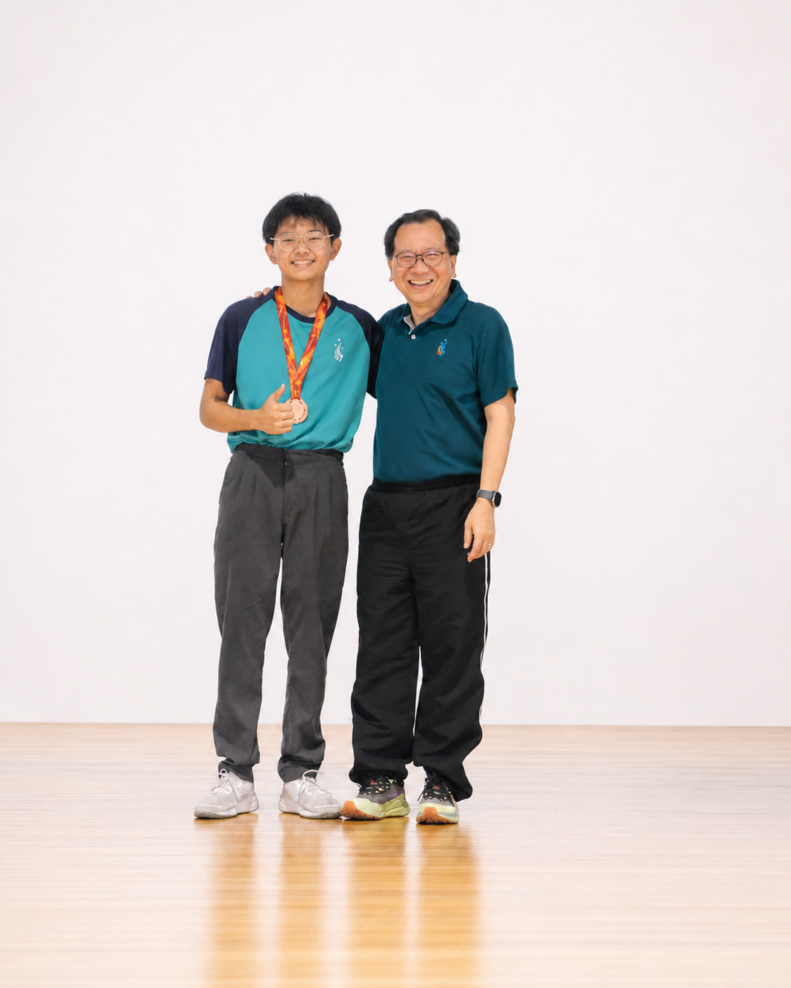 a boy with a medal stands next to the principal on stage