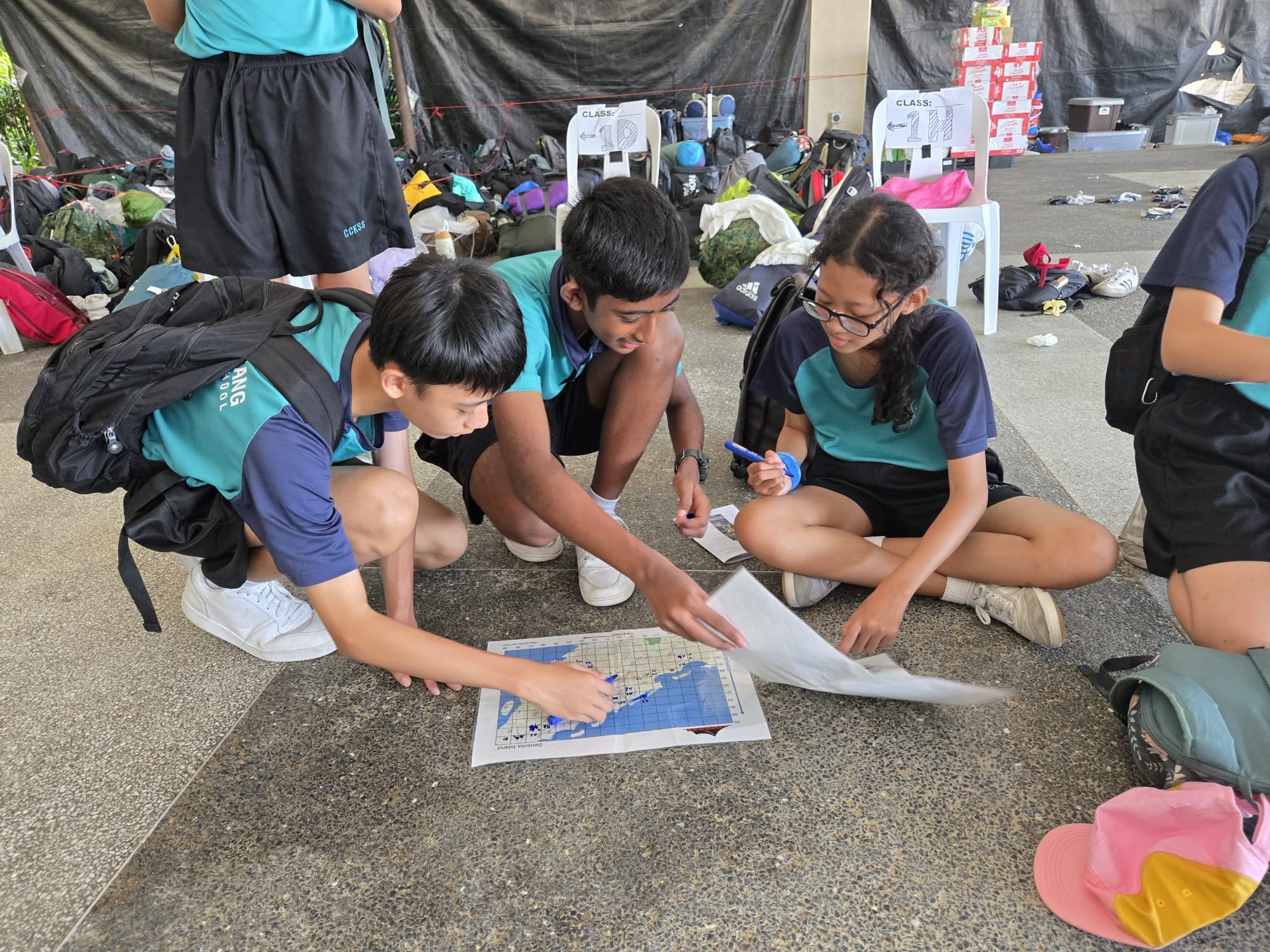 3 students looking at a map