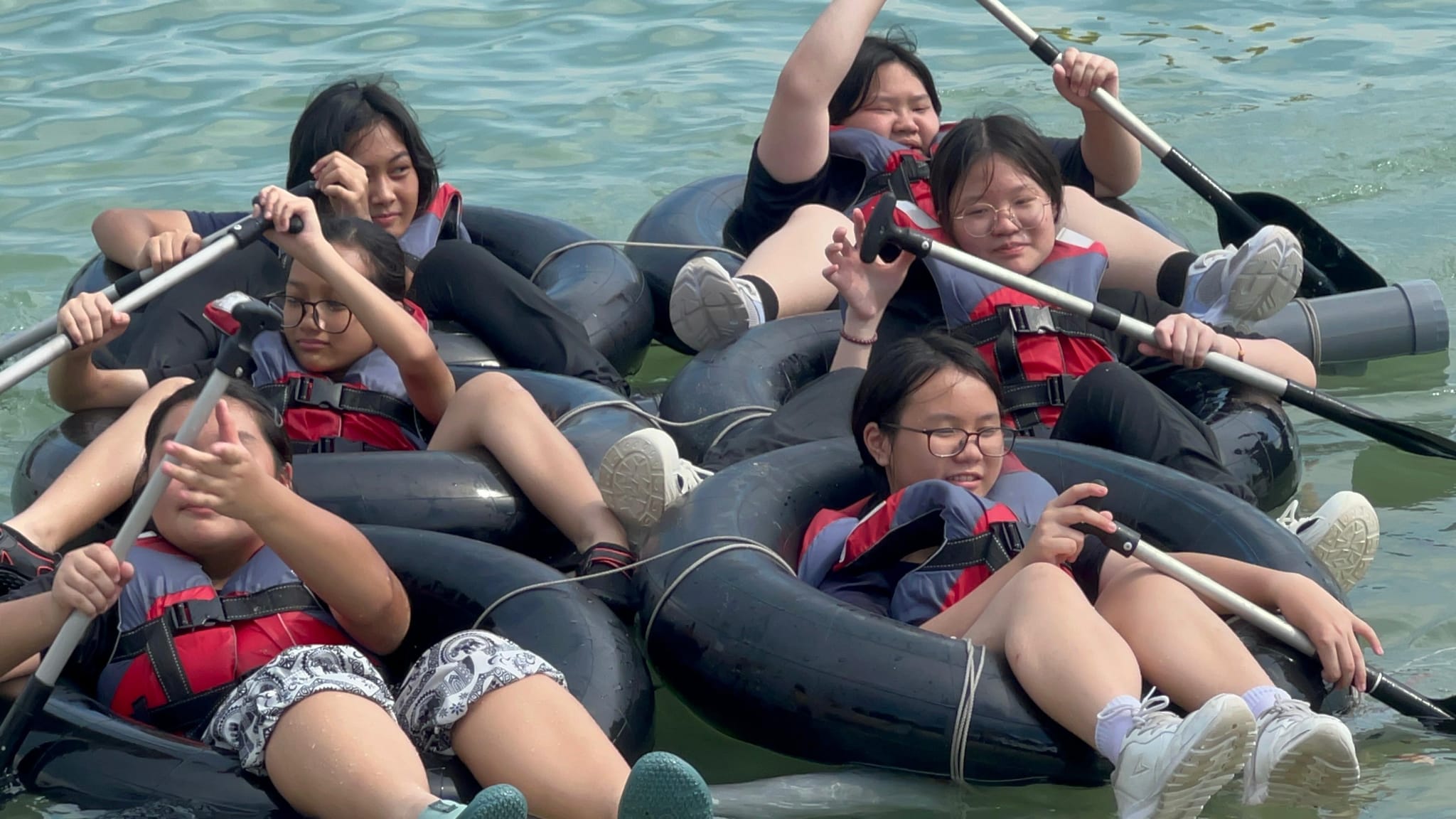 students trying to row their raft in the water