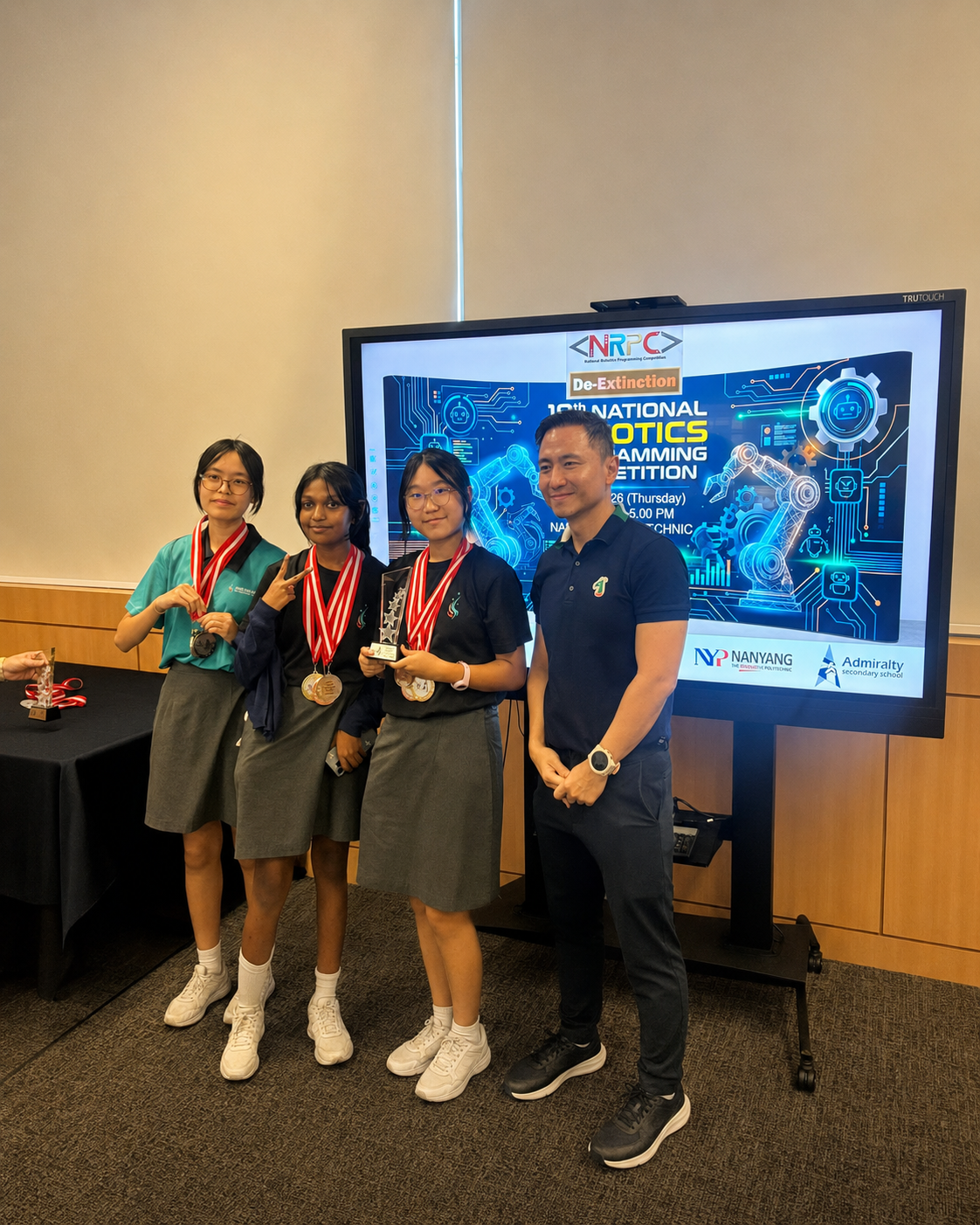 three girls with medals stand next to a man