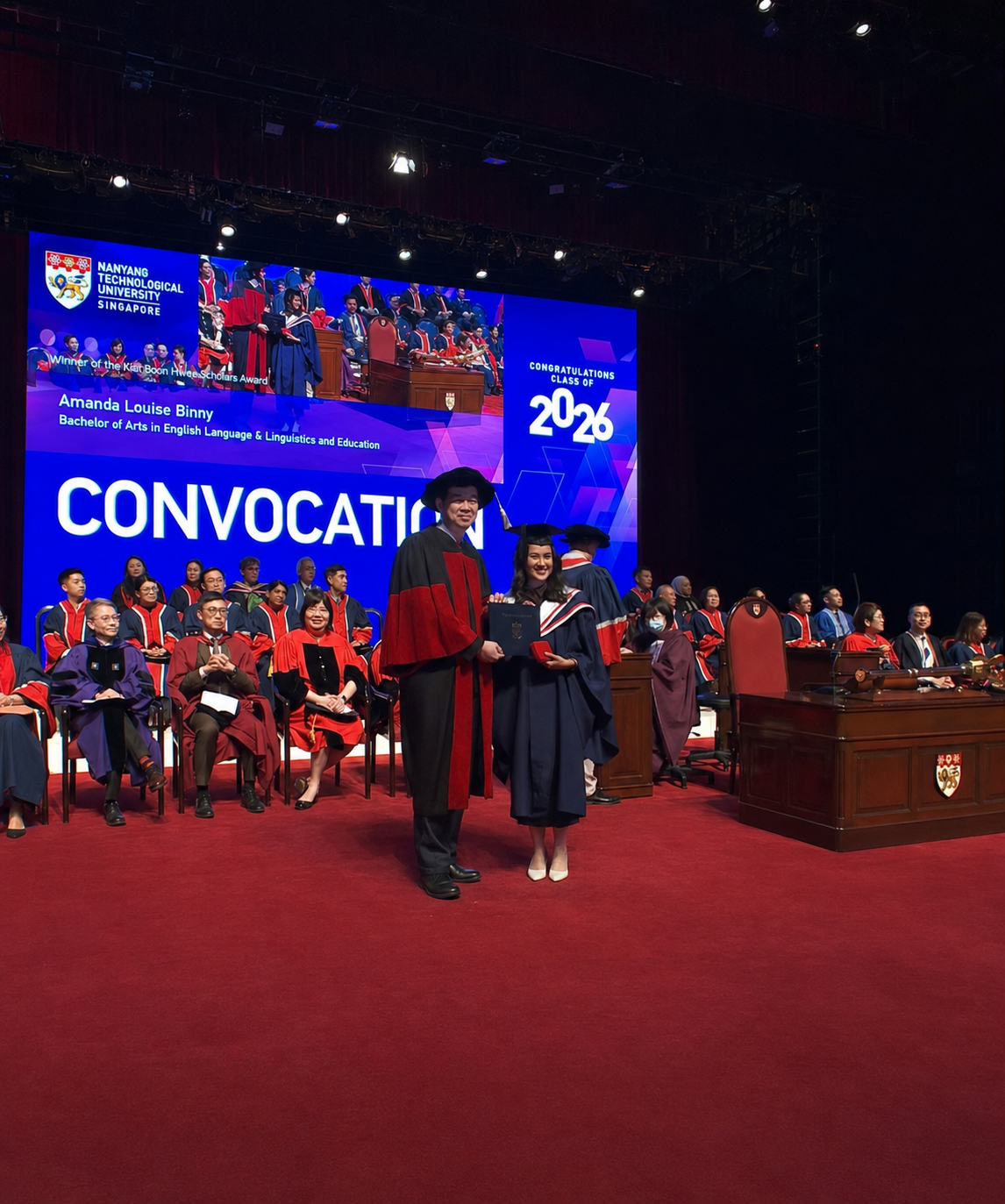A girl in graduation gown receives her degree from an academic in a graudation gown
