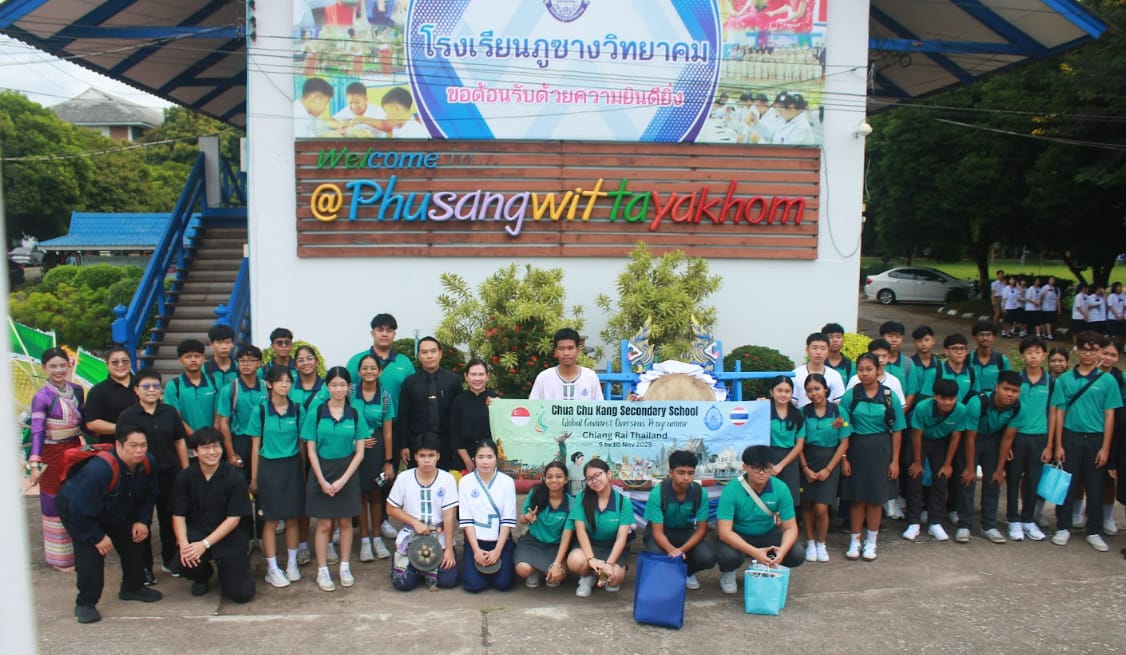 A large group of students in green uniforms pose outside Phusangwittayakhom school in Chiang Rai, Thailand.