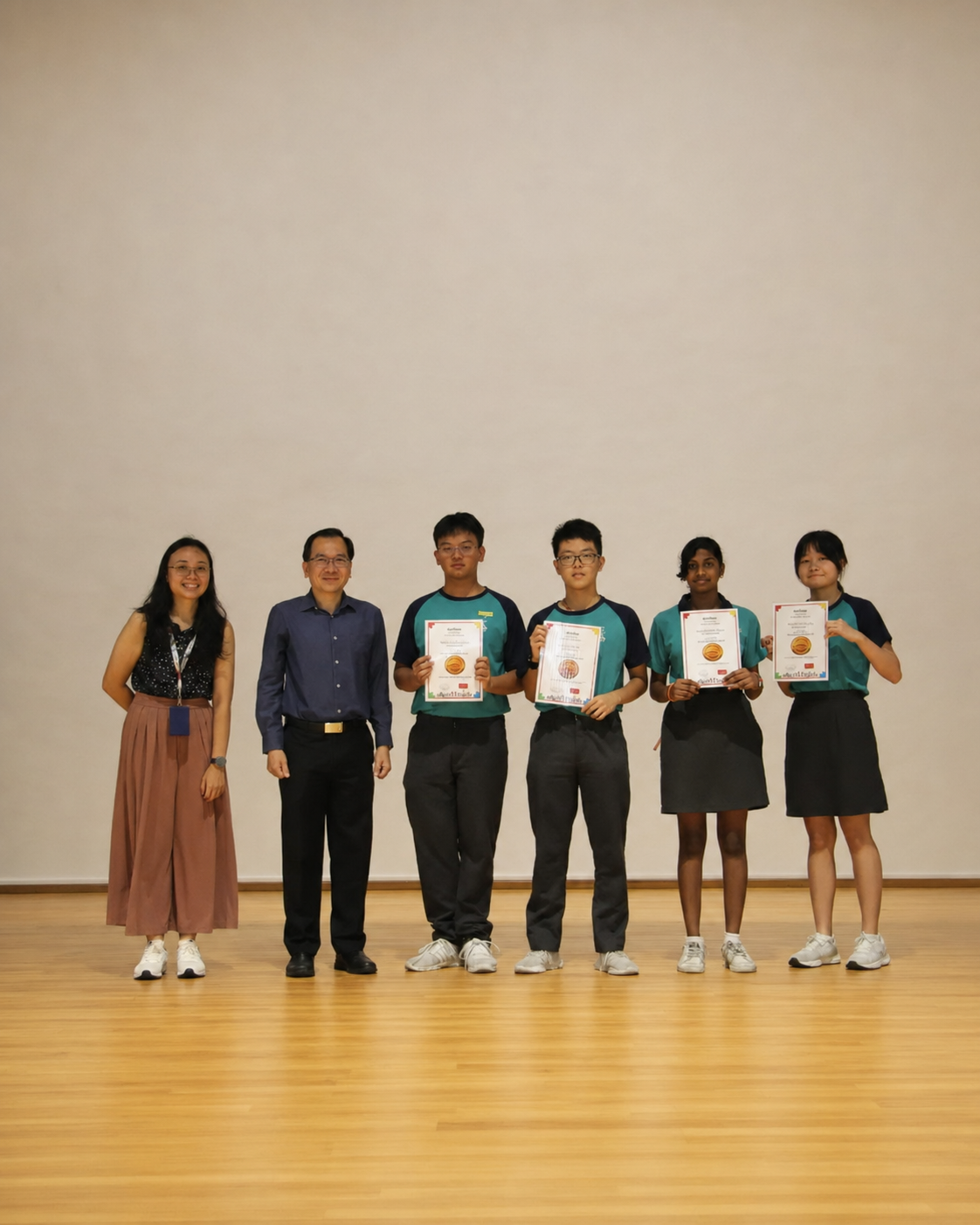 4 students and 1 teacher pose on the stage with certificates