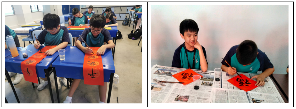 Students practice Chinese calligraphy on red paper strips using ink brushes at classroom desks.