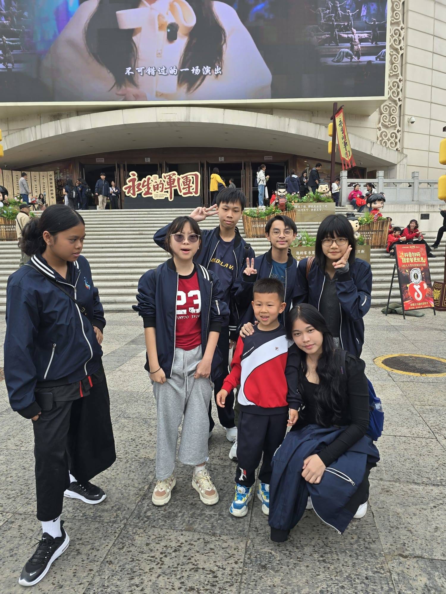 a group of students pose with a little boy