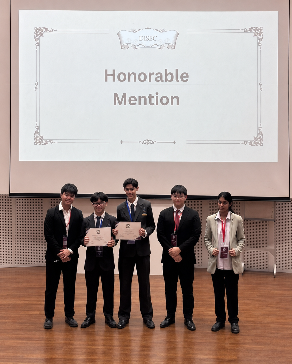 a group of students holding certificates in front of a screen