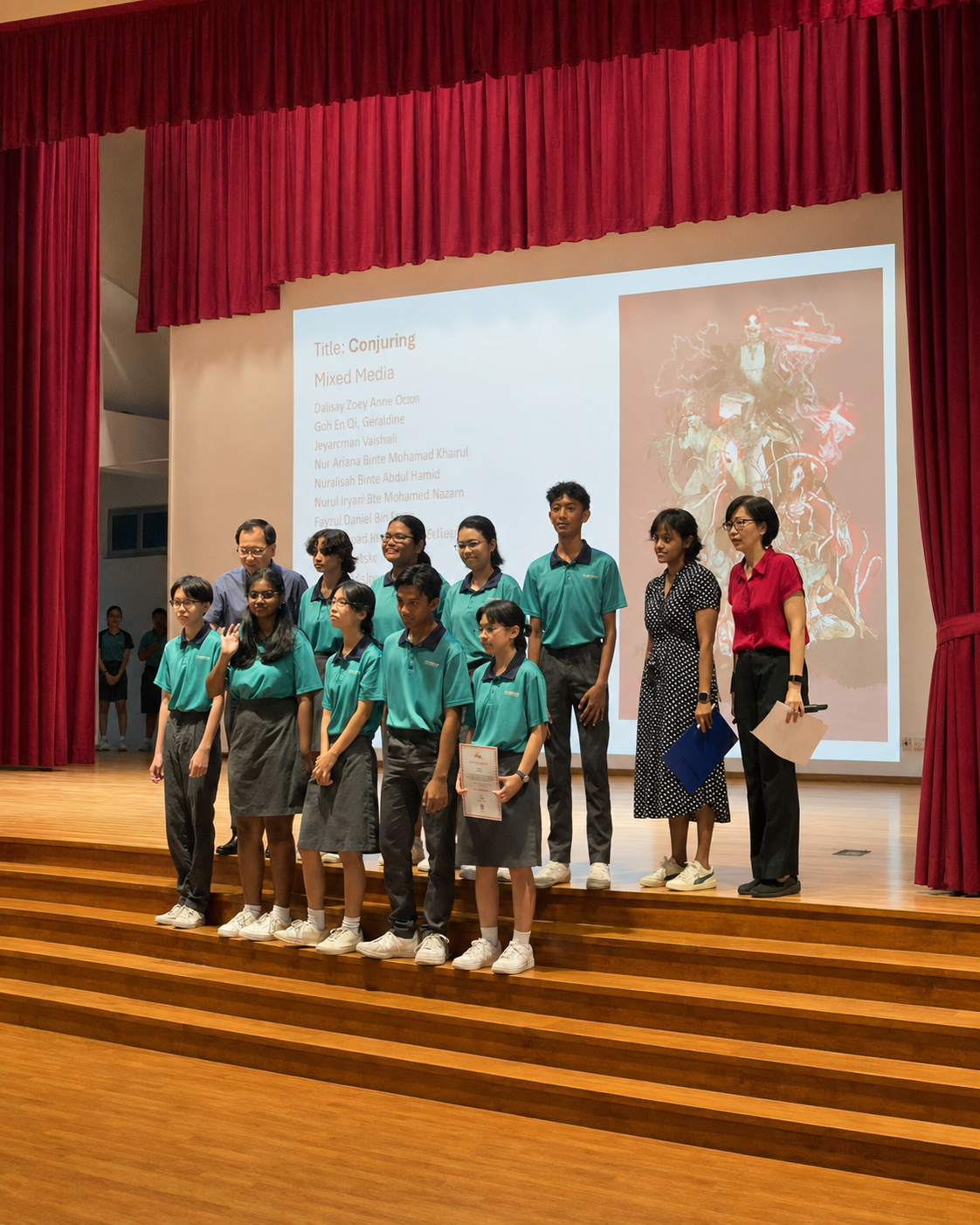 A group of students in teal uniforms pose with two adult teachers, one student holding a certificate.