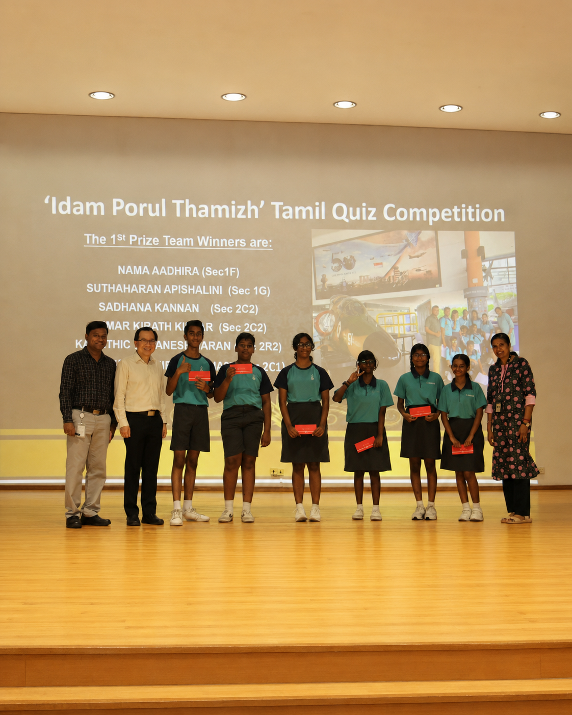 5 students and 3 teachers pose together on stage