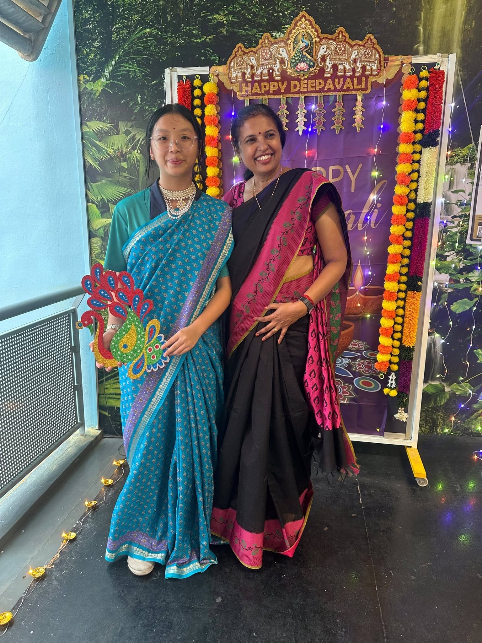 A student and teacher stand together in traditional Indian wear