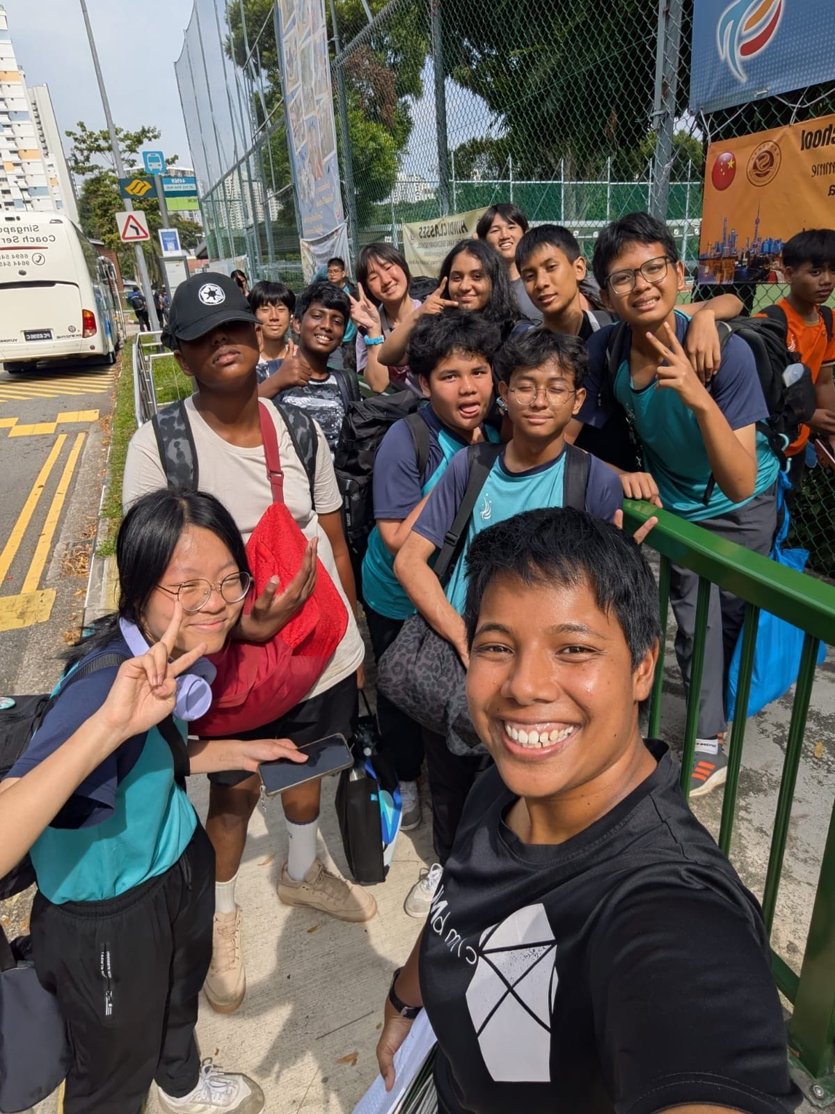 students posing for a photo at a bus stop