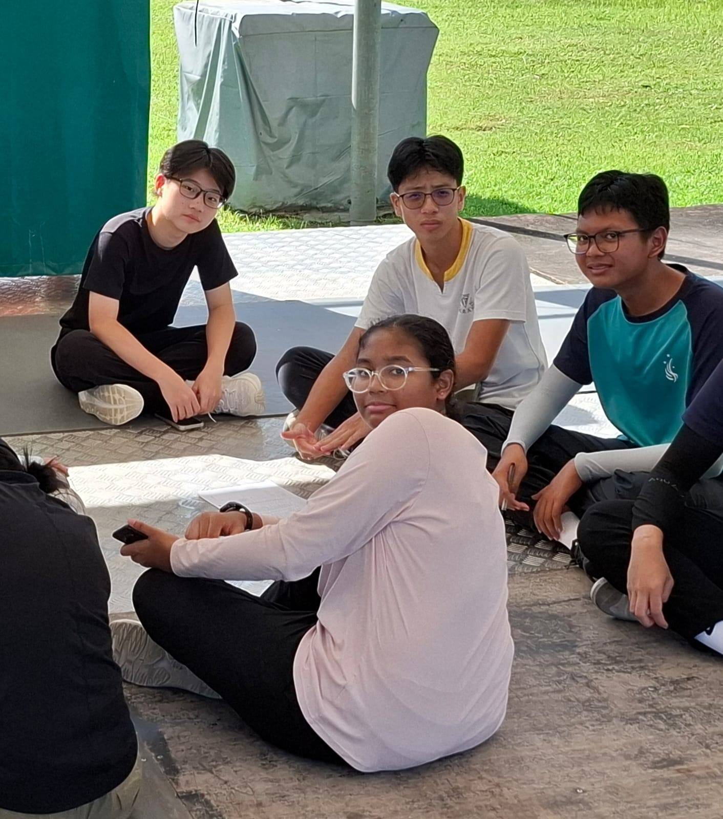 Students sitting down on the floor