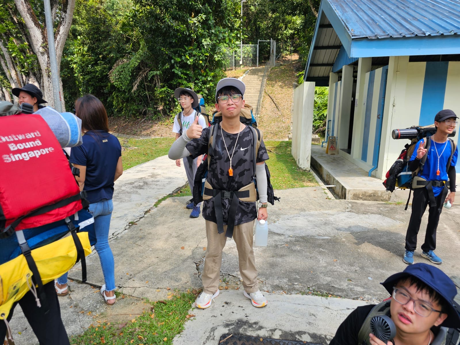 one student posing with a hiking bag