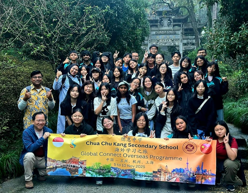 Group of students and teachers pose outdoors holding a Chua Chu Kang Secondary School Global Connect Overseas Programme banner.