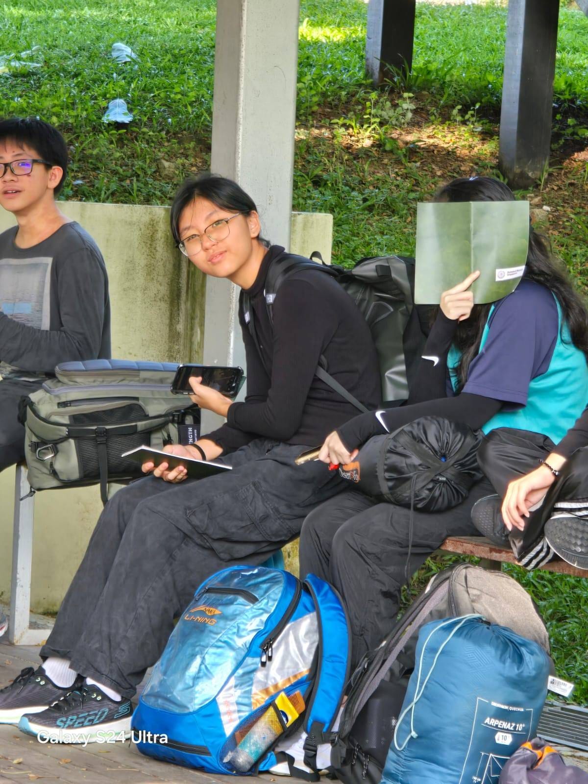 2 students sitting down with bags