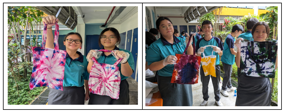 Students in teal uniforms proudly display colorful tie-dye tote bags they created outdoors.