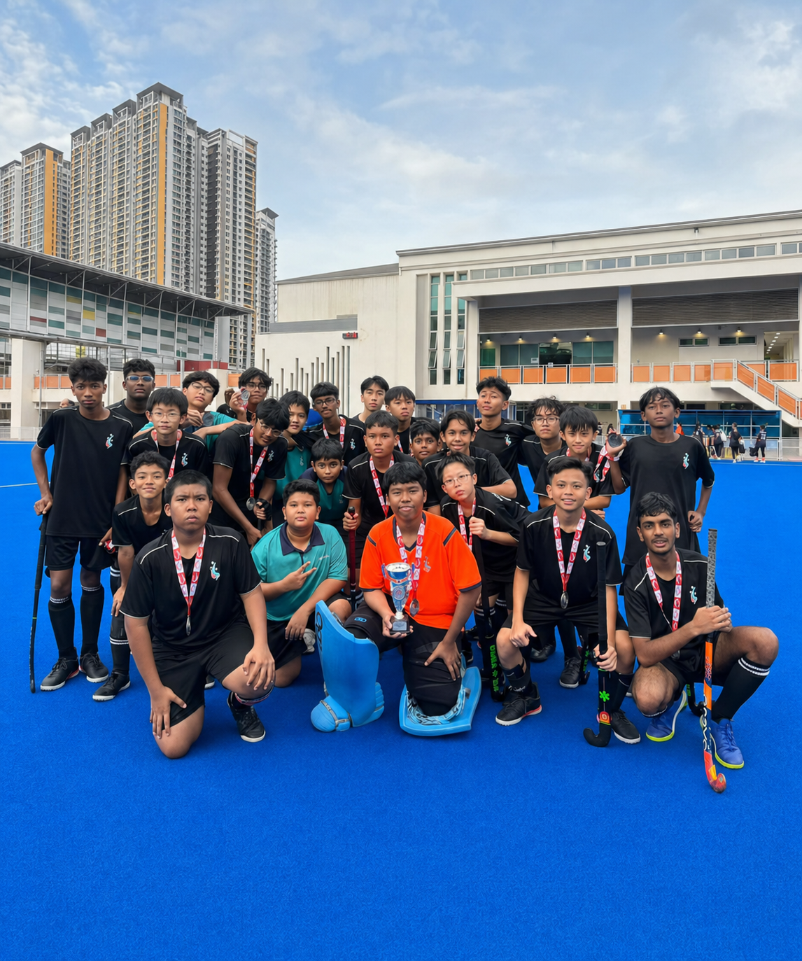hockey students huddle for a photo on the pitch