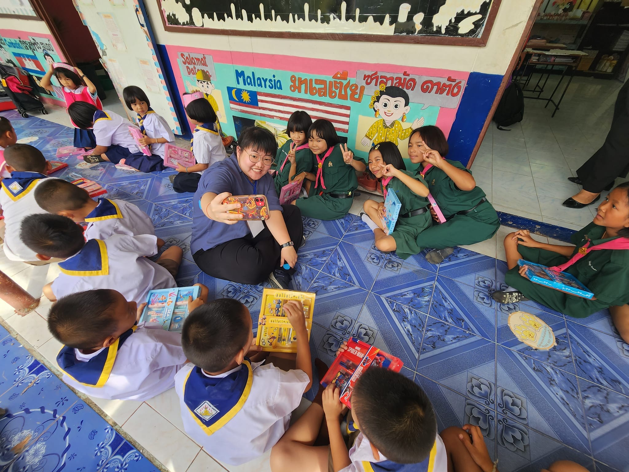 a teacher takes a selfie with a small group of Thai girl scouts.