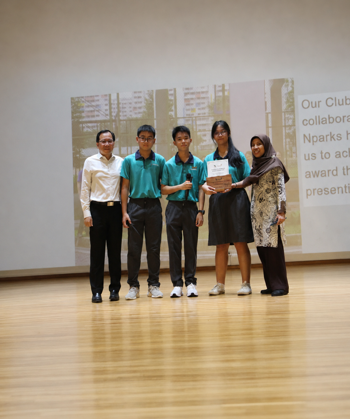 2 adults and 3 students stand on stage