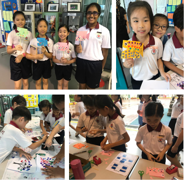 Students in school uniforms display colorful fish artwork and work on craft projects at tables.