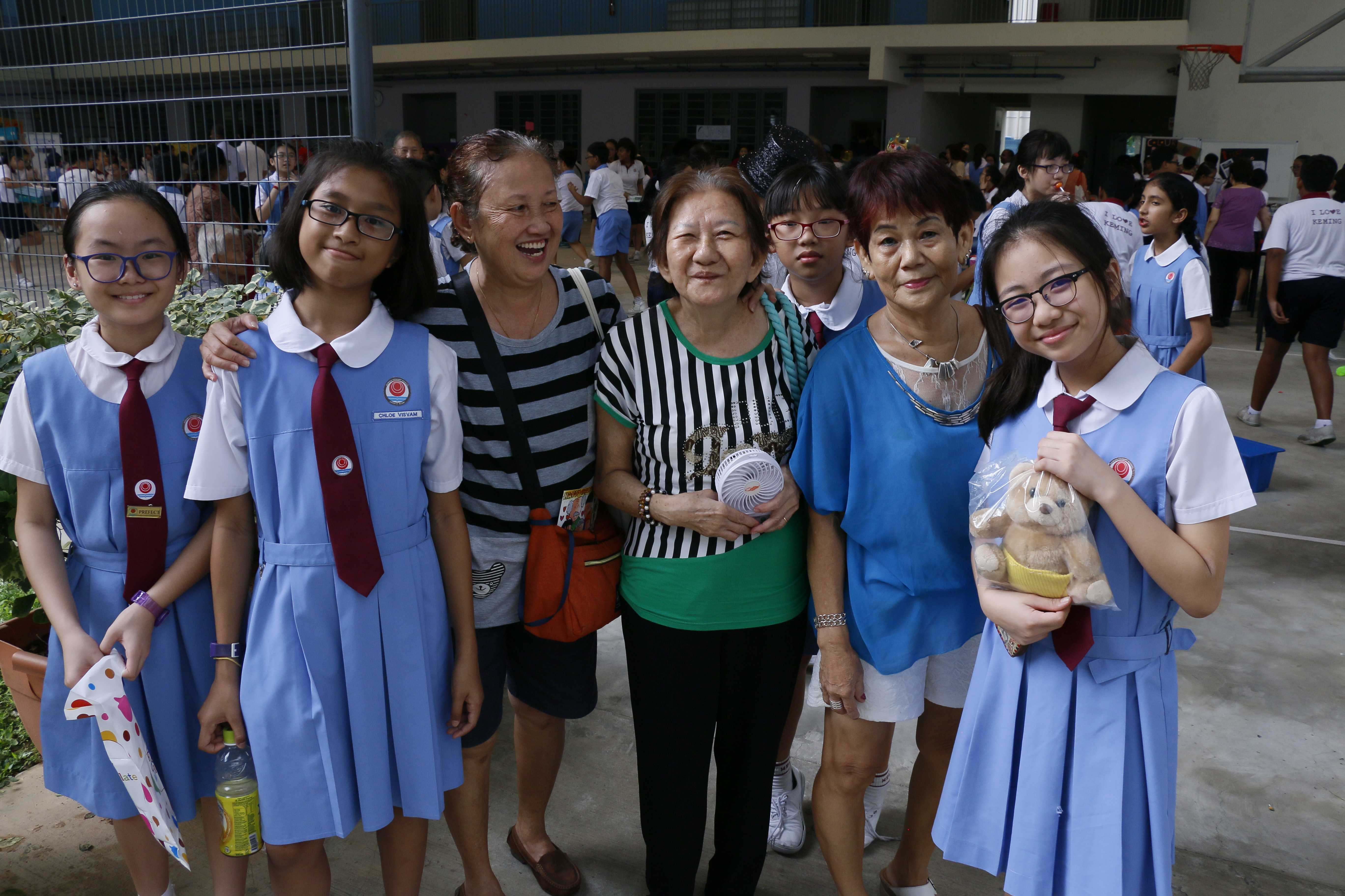students taking picture with senior citizens
