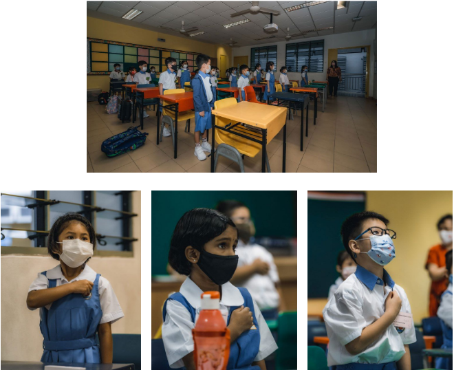 Students in school uniforms and face masks stand at spaced desks in a classroom, with close-ups of three children.